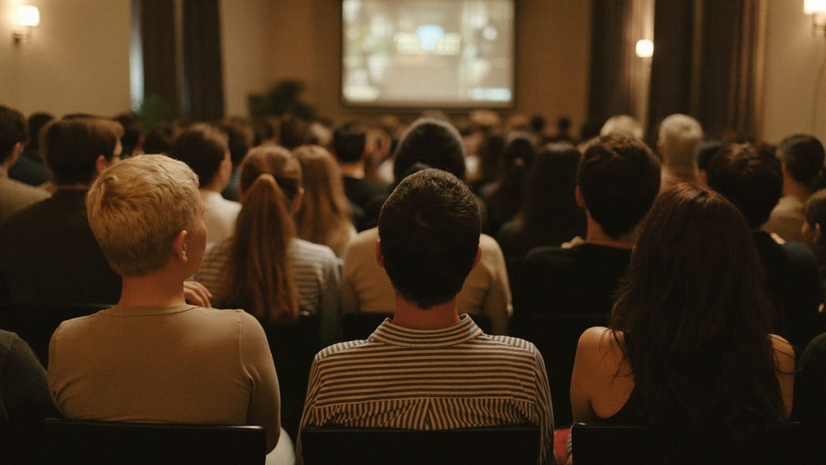 A seated audience of parents listening to an evening presentation