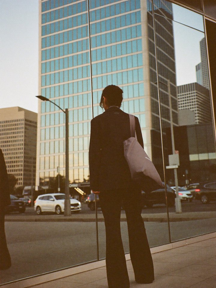 Illustrative photo: a student looking up at a glass office tower