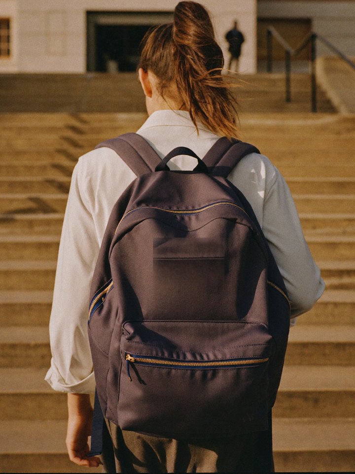 Illustrative photo: a student walking up the steps of a university building